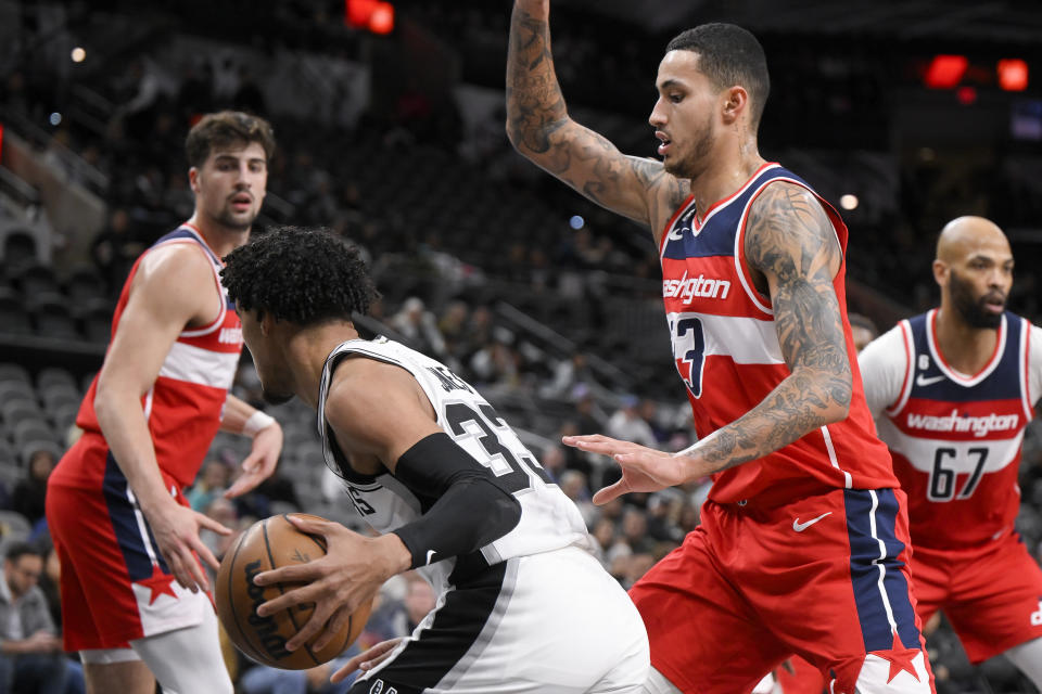 Washington Wizards' Kyle Kuzma, right, defends San Antonio Spurs' Tre Jones during the first half of an NBA basketball game, Monday, Jan. 30, 2023, in San Antonio. (AP Photo/Darren Abate)