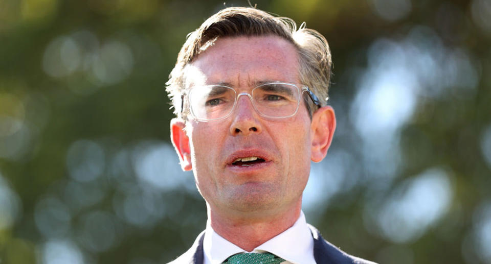 NSW Premier Dominic Perrottet with a concerned look on his face at a press conference.