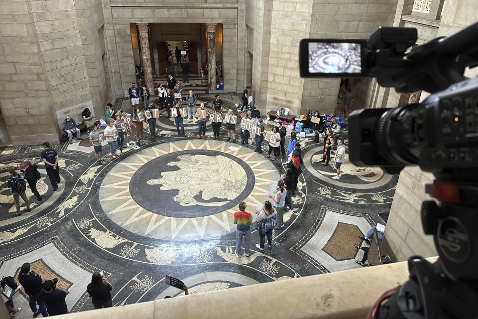 FILE - Protesters gather inside the State Capitol building on Friday, May 19, 2023, in Lincoln, Neb., before lawmakers were scheduled to begin debating a bill that will ban abortions at 12 weeks of pregnancy and also ban gender-affirming care for transgender minors. Republican-led state legislatures are again considering bills restricting medical care for transgender youth and some adults, a year after a wave of high-profile bills became law.(AP Photo/Nick Ingram, File)