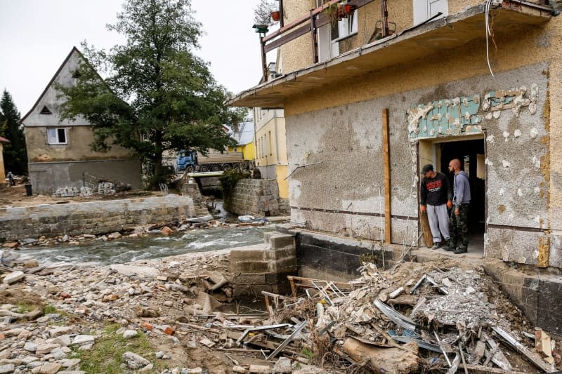 Men look at debris from destroyed buildings as massive flooding affected tourist resorts in southern Poland. Dominika Zarzycka/SOPA Images via ZUMA Press Wire/dpa