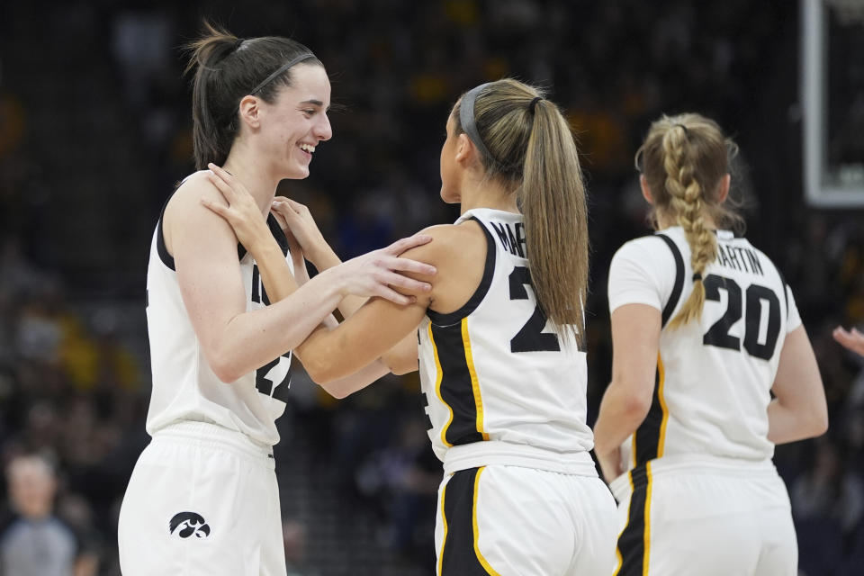 Iowa guards Caitlin Clark, left, and guard Gabbie Marshall, center, hug during the second half of an NCAA college basketball game in the final of the Big Ten women's tournament Sunday, March 10, 2024, in Minneapolis. (AP Photo/Abbie Parr)
