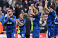 Manchester United's English striker Wayne Rooney (L), Welsh midfielder Ryan Giggs (2nd R) and Northern Irish defender Jonny Evans (R) applaud their supporters after the English Premier League football match between Sunderland and Manchester United at The Stadium of Light in Sunderland, north-east England on May 13, 2012. AFP PHOTO/ANDREW YATES RESTRICTED TO EDITORIAL USE. No use with unauthorized audio, video, data, fixture lists, club/league logos or “live” services. Online in-match use limited to 45 images, no video emulation. No use in betting, games or single club/league/player publications.ANDREW YATES/AFP/GettyImages