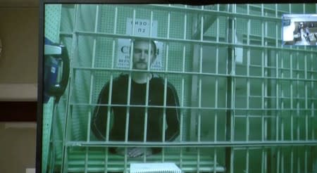 A still image shows actor Ustinov on a screen via a video link during a court hearing to review his jailing in Moscow