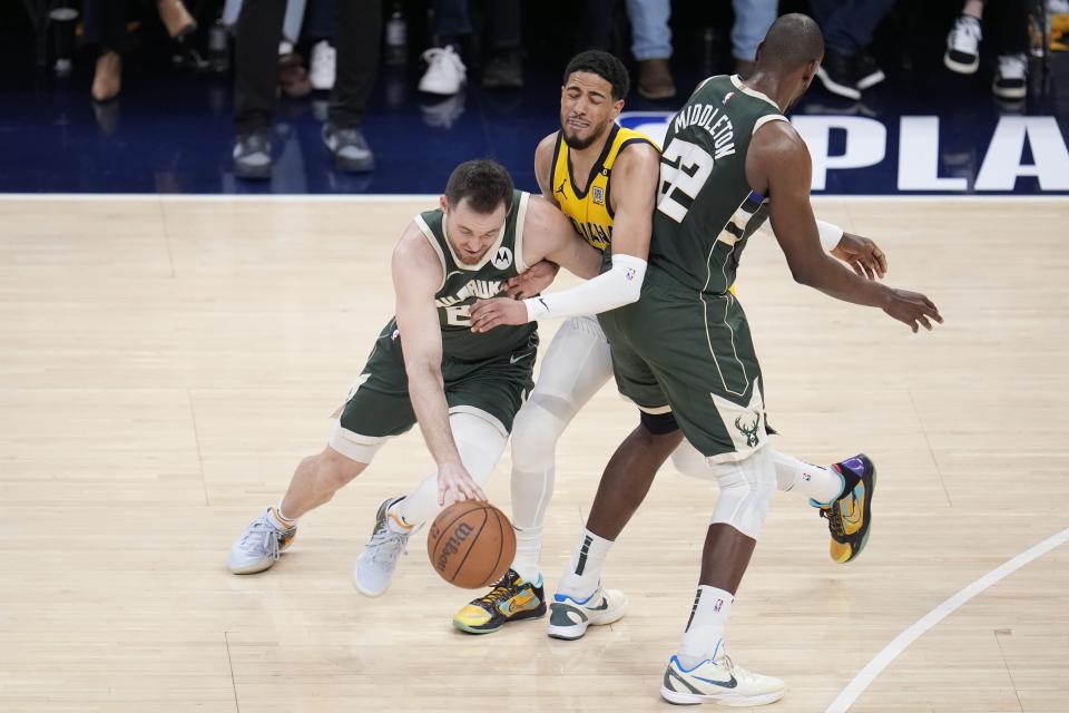 Milwaukee Bucks' Pat Connaughton (24) goes to the basket against Indiana Pacers' Tyrese Haliburton (0) as Khris Middleton sets a pick during the first half of Game 4 of the first round NBA playoff basketball series, Sunday, April 28, 2024, in Indianapolis. (AP Photo/Michael Conroy)