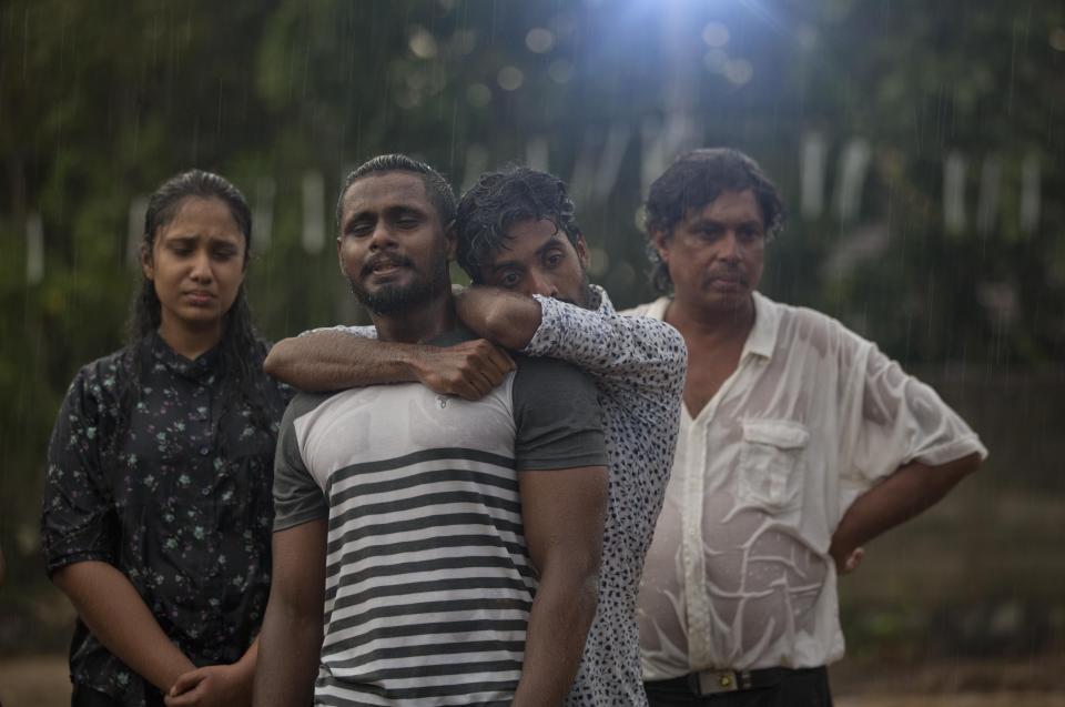 FILE - In this April 22, 2019 file photo, mourners grieve at the burial of three members of the same family victims of an Easter Sunday bomb blast at St. Sebastian Church in Negombo, Sri Lanka. In a video released on April 29, the Islamic State group's leader extolled militants in Sri Lanka for “striking the homes of the crusaders in their Easter, in vengeance for their brothers in Baghouz,” a reference to IS’ last bastion in eastern Syria, which was captured by U.S.-backed fighters in March. (AP Photo/Gemunu Amarasinghe, File)