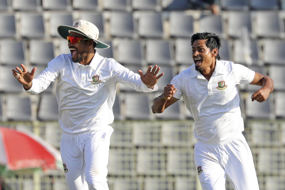 Bangladeshi Cricketer Taijul Islam, right, and Najmul Hossain Shanto celebrate the dismissal of New Zealand's Henry Nicholls during the fourth day of the first test cricket match at Sylhet, Bangladesh, Friday, Dec. 1, 2023. (AP Photo/Mosaraf Hossain)