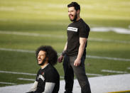 Free agent quarterback Colin Kaepernick, left, laughs will stretching before a workout for NFL football scouts and media, Saturday, Nov. 16, 2019, in Riverdale, Ga. (AP Photo/Todd Kirkland)