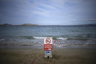 A sign reading "swimming prohibited" sits on a beach with high levels of pollution the morning after a storm passed through Marseille, southern France, Thursday, Aug 18, 2022. (AP Photo/Daniel Cole)