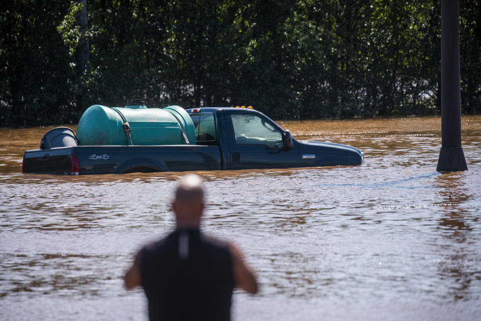 A man looks at a vehicle flooded as a result of the remnants of Hurricane Ida in a parking lot in Somerville, N.J., Thursday, Sept. 2, 2021. (AP Photo/Eduardo Munoz Alvarez)