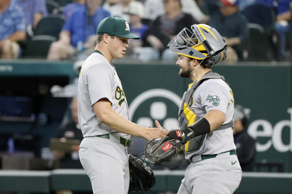 Oakland Athletics pitcher Mason Miller, left, and Oakland Athletics catcher Shea Langeliers, right, celebrate after a victory over the Texas Rangers in a baseball game Thursday, April 11, 2024, in Arlington, Texas. (AP Photo/Michael Ainsworth)