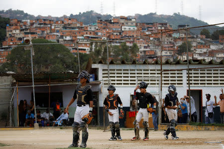 Rivaldo Avila (L) and teammates take part in a baseball showcase in Caracas, Venezuela August 25, 2017. REUTERS/Carlos Garcia Rawlins/Files