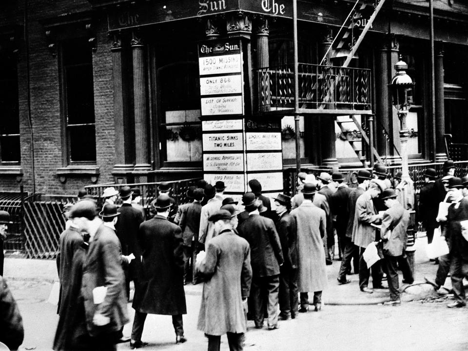 People are gathered in front of the The New York Sun's building on Broadway, reading the bulletin board with latest news about the Titanic, in April 1912.