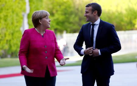 FILE PHOTO: German Chancellor Angela Merkel and French President Emmanuel Macron talk as they arrive at a ceremony at the Chancellery in Berlin, Germany, May 15, 2017. REUTERS/Pawel Kopczynski/File Photo