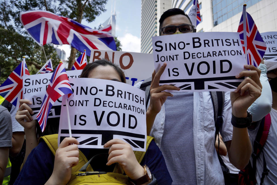 Protesters hold placards and wave British flags during a peaceful demonstration outside the British Consulate in Hong Kong, Sunday, Sept. 15, 2019. Hundreds of Hong Kong activists rallied outside the Consulate for a second time this month, bolstering calls for international support in their months-long protests for democratic reforms in the semi-autonomous Chinese territory. (AP Photo/Vincent Yu)