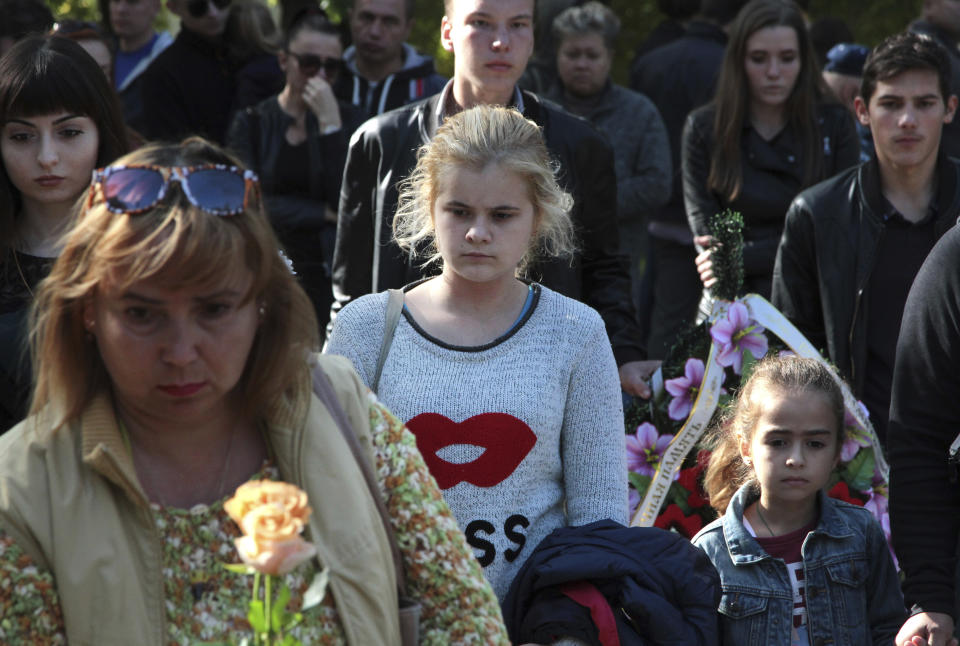 People commemorate the victims of the attack on a vocational college, in Kerch, Crimea, Thursday, Oct. 18, 2018. Authorities on the Crimean Peninsula were searching for a possible accomplice of the student who carried out a shooting and bomb attack on a vocational school Wednesday, killing 20 people and wounding more than 50 others, an official said Thursday. (AP Photo)