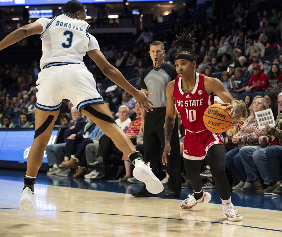 North Carolina State guard Aziaha James (10) dribbles past Old Dominion guard Simone Cunningham (3) during the first half of an NCAA college basketball game Wednesday, Dec. 20, 2023, in Norfolk, Va. (AP Photo/Mike Caudill)