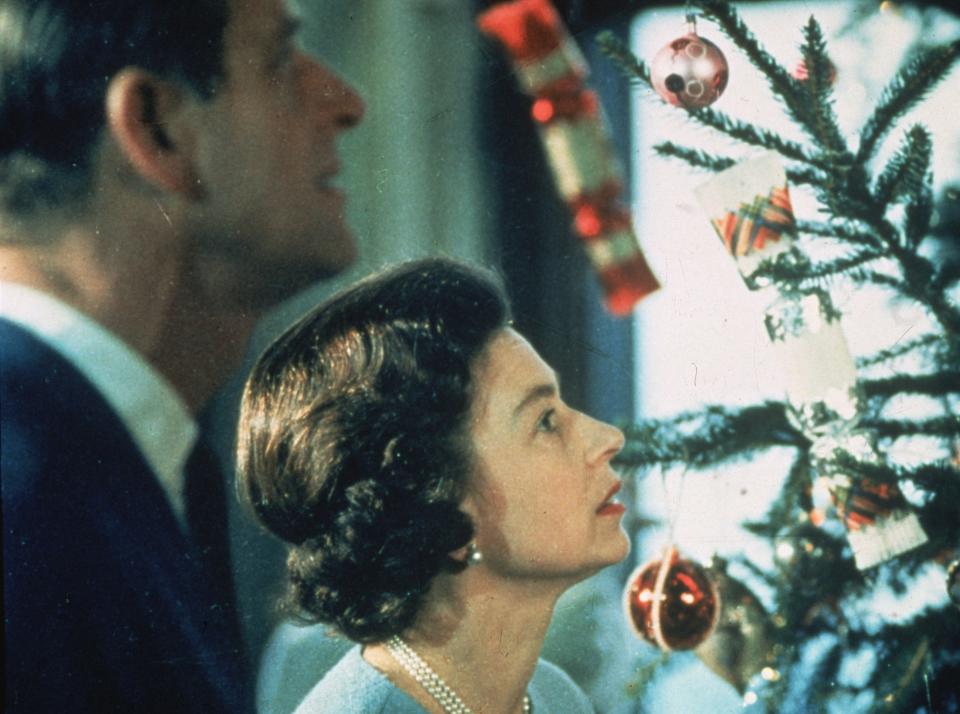 June 1969: Queen Elizabeth II and Prince Philip look at their decorated Christmas tree while filming a television program about life in the British royal family. (Photo by Fox Photos/Getty Images)