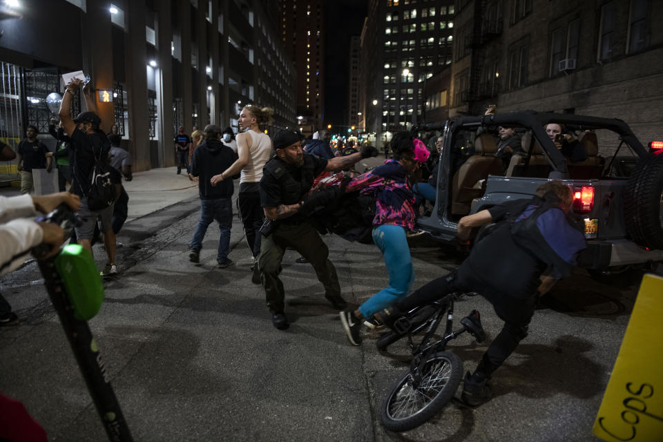 In this May 29, 2020, photo, a police officer grabs a protester during a rally calling for an end to police violence and justice for George Floyd in Detroit. (Nicole Hester/Mlive.com/Ann Arbor News via AP)