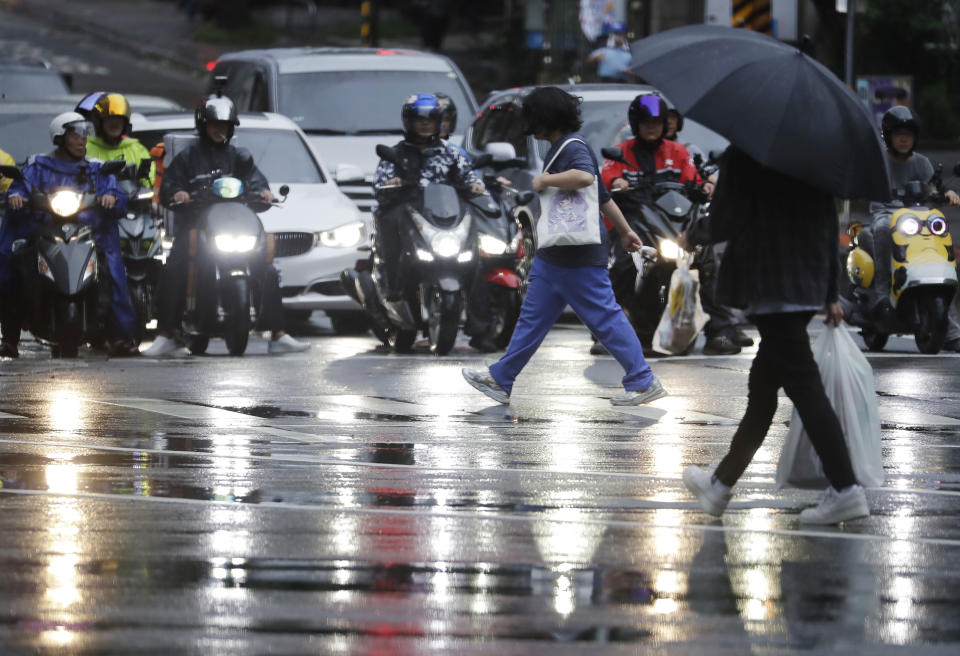 People walk in the rain as Typhoon Koinu approaches to Taiwan in Taipei, Taiwan, Wednesday, Oct. 4, 2023. (AP Photo/Chiang Ying-ying)