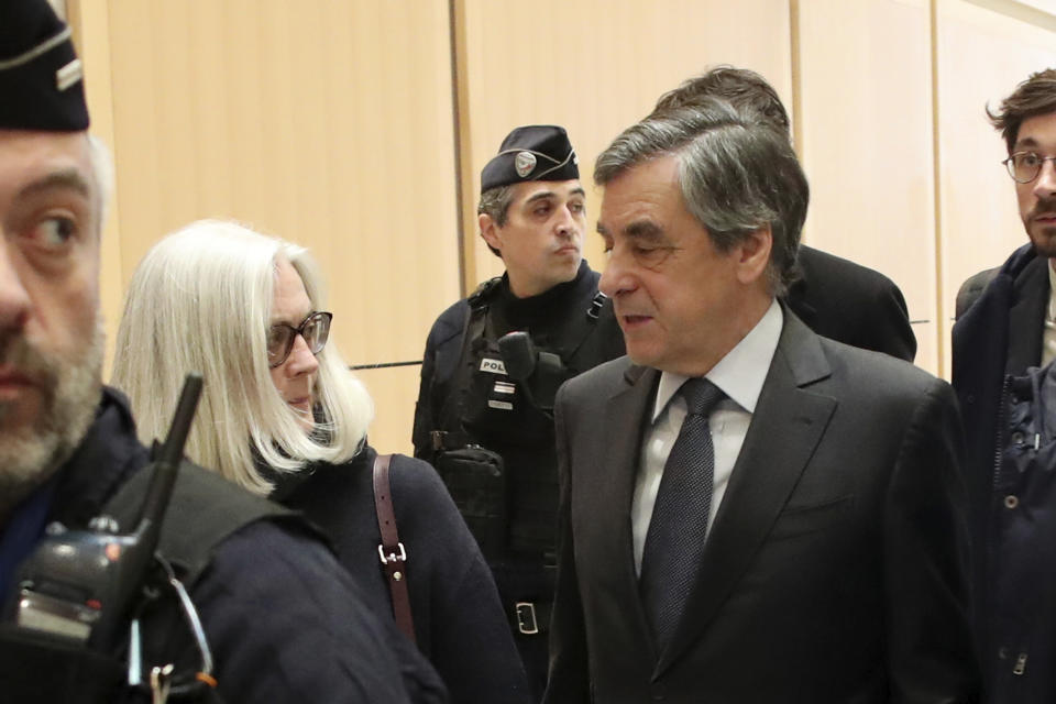 France's former Prime Minister Francois Fillon, right, and his wife Penelope, left, leave the Paris courthouse, in Paris, Monday, Feb. 24, 2020. He could have been president of France. Instead, former Prime Minister Francois Fillon is going on trial to face fraud charges after he used public funds to richly pay his wife and children for work they allegedly never performed. (AP Photo/Thibault Camus)