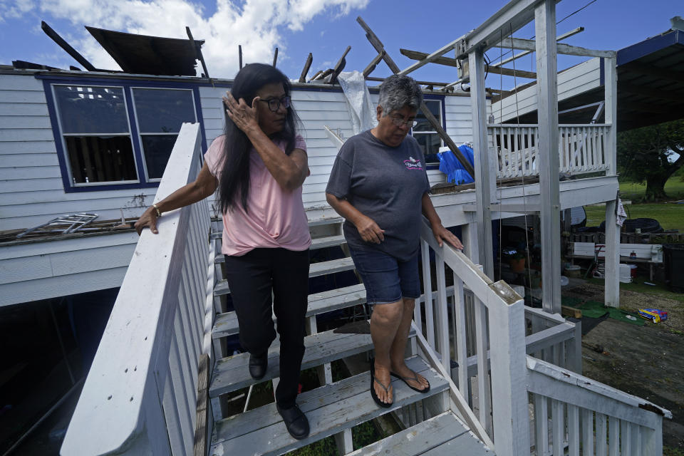Louise Billiot, left, a member of the United Houma Nation Indian tribe, walks the home of her friend and tribal member Irene Verdin, which was heavily damaged from Hurricane Ida nine months before, along Bayou Pointe-au-Chien, La., Thursday, May 26, 2022. (AP Photo/Gerald Herbert)