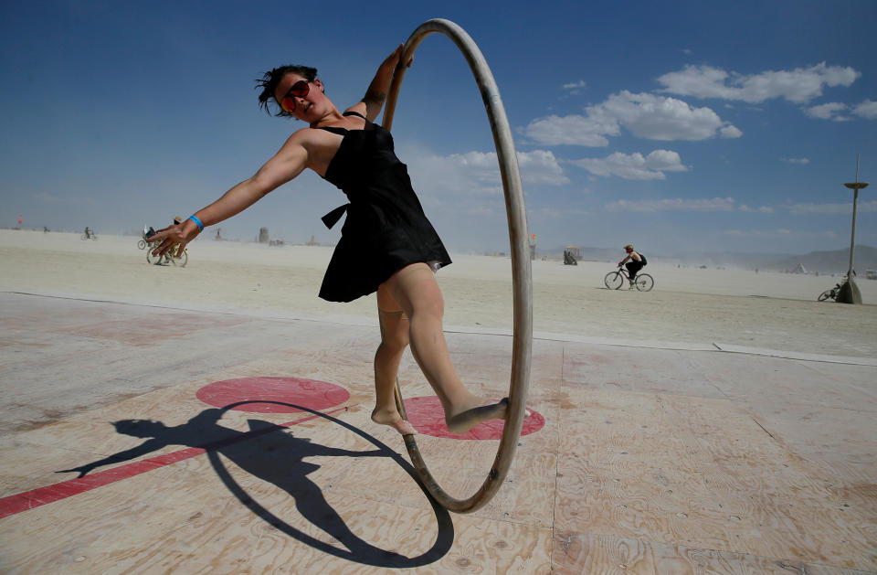 <p>Burning Man participant Kylie Webb of Santa Cruz, California spins inside a metal hoop on a roller disco floor as approximately 70,000 people from all over the world gathered for the 1st full day of the annual Burning Man arts and music festival in the middle of the Black Rock Desert of Nevada, Aug. 28, 2017. (Photo: Jim Bourg/Reuters) </p>