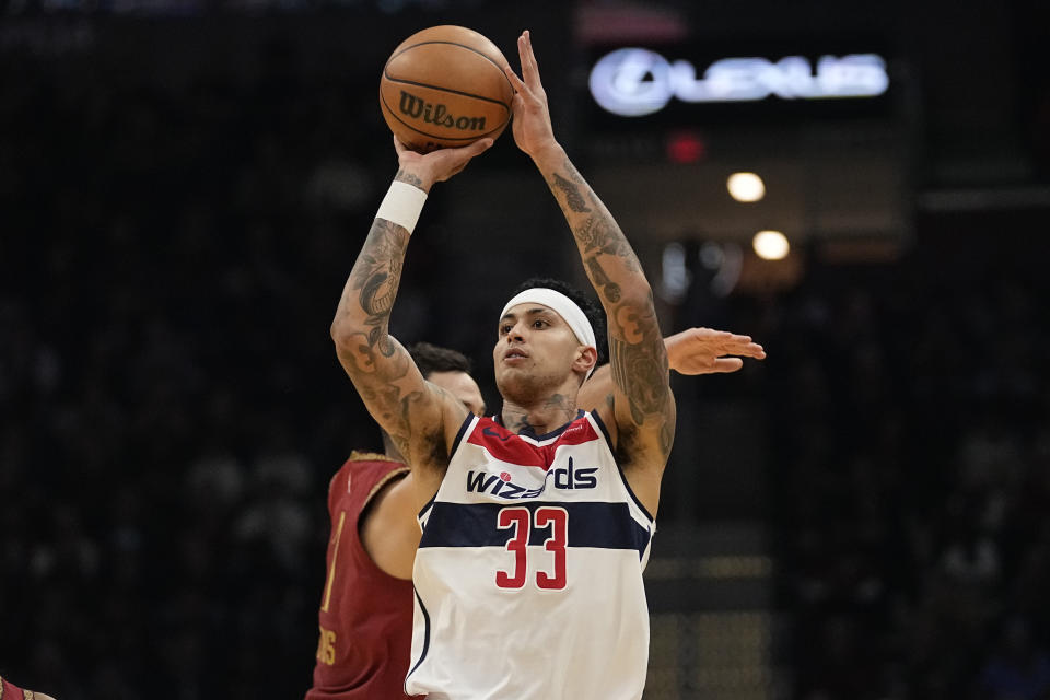 Washington Wizards forward Kyle Kuzma (33) shoots in front of Cleveland Cavaliers guard Max Strus, rear, in the first half of an NBA basketball game Wednesday, Jan. 3, 2024 in Cleveland. (AP Photo/Sue Ogrocki)