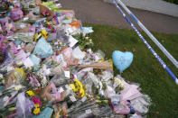 A floral tribute lies by the cordoned off area where a member of Parliament was killed on Friday, in Leigh-on-Sea, Essex, England, Saturday, Oct. 16, 2021. David Amess, a long-serving member of Parliament was stabbed to death during a meeting with constituents at a church in Leigh-on-Sea on Friday, in what police said was a terrorist incident. A 25-year-old British man is in custody. (AP Photo/Alberto Pezzali)