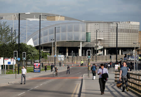 Commuters walk to work as a police cordon surrounds the Manchester Arena, Britain May 23, 2017. REUTERS/Andrew Yates