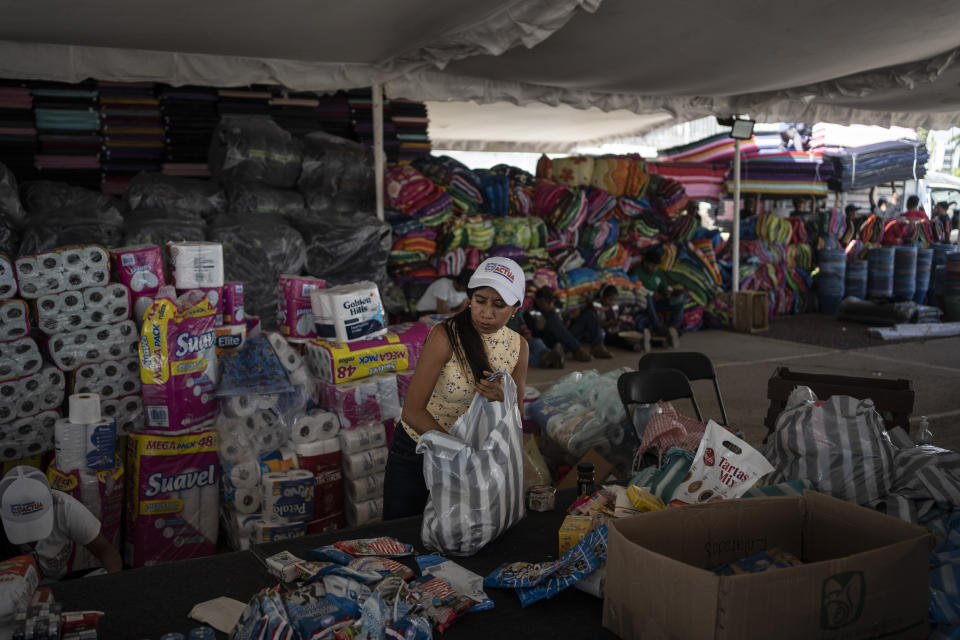A volunteer receives humanitarian aid at a collection center in the aftermath of Hurricane Otis in Acapulco, Mexico, Sunday, Oct. 29, 2023. Mexican authorities have raised the toll to 48 dead from the Category 5 storm that struck the country's southern Pacific coast. (AP Photo/Felix Marquez)