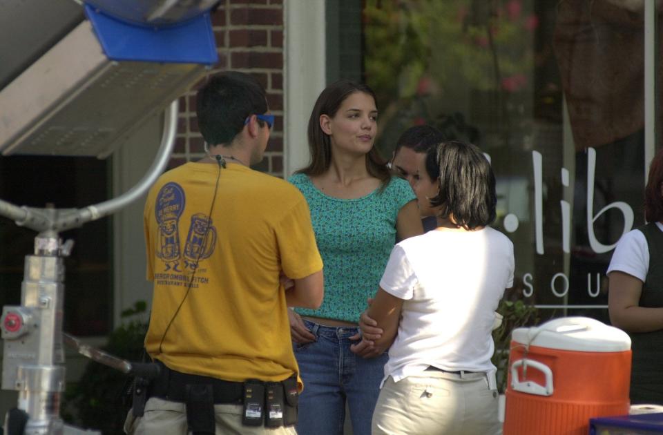 Katie Holmes talks with crew members in between shots while filming on Market Street in Wilmington for "Dawson's Creek," early 2000s, around the time she hosted "Saturday Night Live."