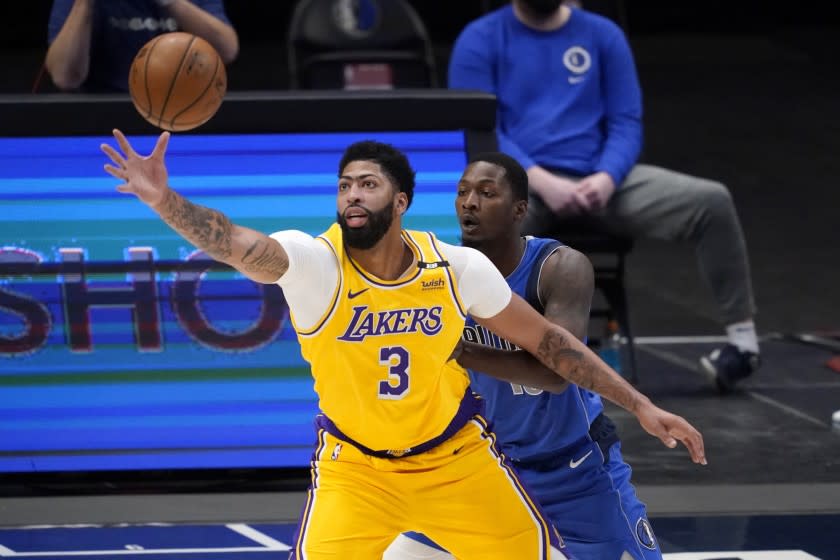 Los Angeles Lakers' Anthony Davis (3) reaches out for a pass as Dallas Mavericks' Dorian Finney-Smith defends in the first half of an NBA basketball game in Dallas, Thursday, April 22, 2021. (AP Photo/Tony Gutierrez)