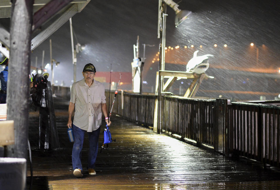 <p>Rogelio Ortiz makes his way off the Pirate’s Landing Fishing Pier as rain from Hurricane Harvey falls on Thursday, Aug. 24, 2017, in Port Isabel, Texas. (Photo: Jason Hoekema/The Brownsville Herald via AP) </p>