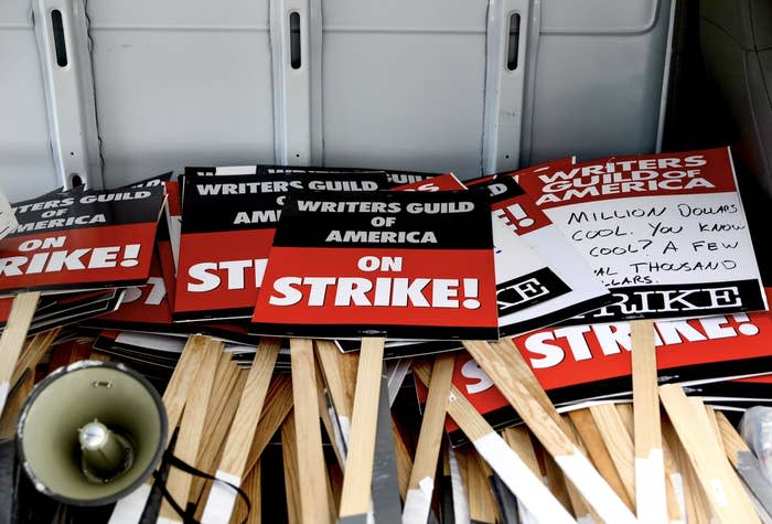 A group of picket signs that say Writers Guild of America on Strike!