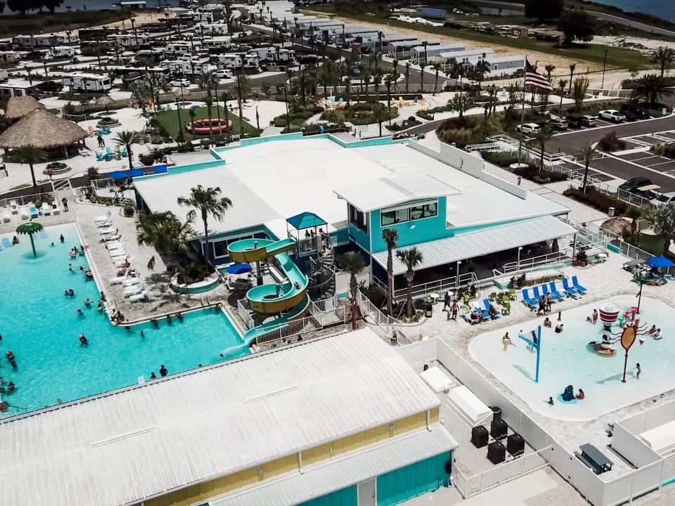 An overhead view of the pools at the camp. There's a waterslide sliding into one pool, and a shallower kids pool nearby.