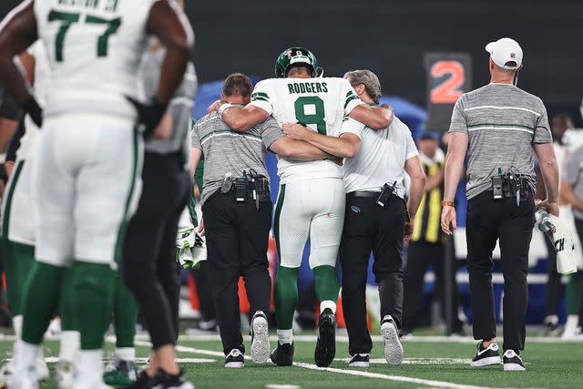 <p> Michael Owens/Getty</p> Aaron Rodgers #8 of the New York Jets is helped off the field for an apparent injury during a game against the Buffalo Bills at MetLife Stadium on September 11, 2023 in East Rutherford, New Jersey.