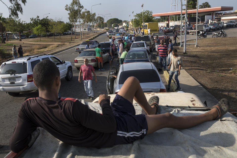 People line the street with their vehicles as they wait to fill up with gas at a fuel station, top right, in Cabimas, Venezuela, Wednesday, May 15, 2019. U.S. sanctions on oil-rich Venezuela appear to be taking hold, resulting in mile-long lines for fuel in the South American nation’s second-largest city, Maracaibo. (AP Photo/Rodrigo Abd)