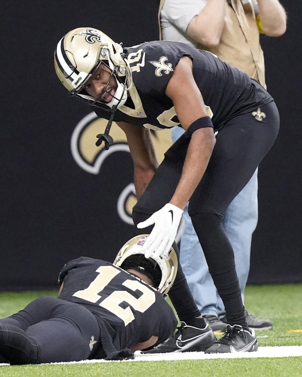 New Orleans Saints wide receiver Tre'Quan Smith (10) looks after wide receiver Chris Olave after Olave scored but hit the turf hard on his head during an NFL football game against the Seattle Seahawks in New Orleans, Sunday, Oct. 9, 2022. (AP Photo/Gerald Herbert)