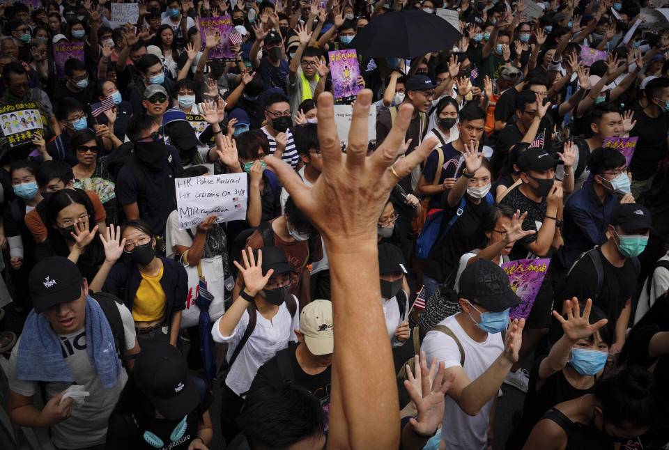 Protesters shows their palms with five fingers open, signifying the five demands of protesters, as they march from Chater Garden to the U.S. consulate in Hong Kong, Sunday, Sept. 8, 2019. Demonstrators in Hong Kong plan to march to the U.S. Consulate on Sunday to drum up international support for their protest movement, a day after attempts to disrupt transportation to the airport were thwarted by police. (AP Photo/Kin Cheung)