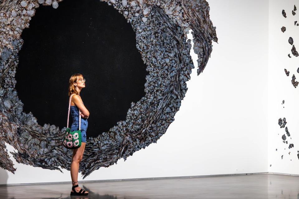 Julia Lanman stands in front of Molly Kaderka's "Ferrous Form/Unform," a mixed-media and handmade marbled paper installation featured in the "ArtNow 2023" biennial exhibit of Oklahoma artists at Oklahoma Contemporary Arts Center in Oklahoma City on Thursday, June 29, 2023.