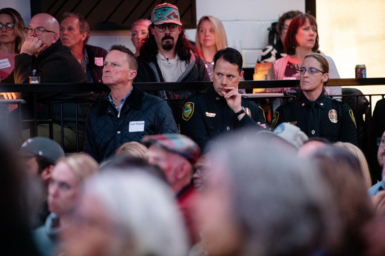 Asheville Police Chief Mike Lamb, center, listens to the State of Downtown presentation at Eulogy in Asheville, March 19, 2024.