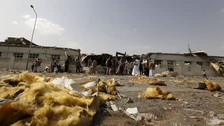 People gather outside a fabric factory after a Saudi-led air strike hit it in Yemen's capital Sanaa July 10, 2015. REUTERS/Khaled Abdullah