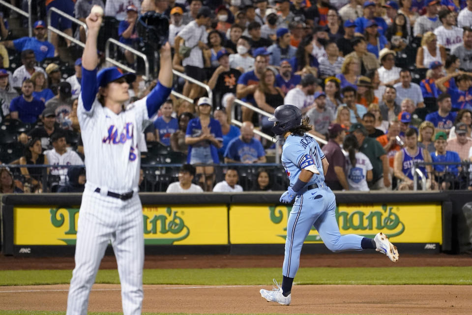 New York Mets relief pitcher Drew Smith, left, waits as Toronto Blue Jays' Bo Bichette runs the bases after hitting a home run during the seventh inning of a baseball game Saturday, July 24, 2021, in New York. (AP Photo/Mary Altaffer)