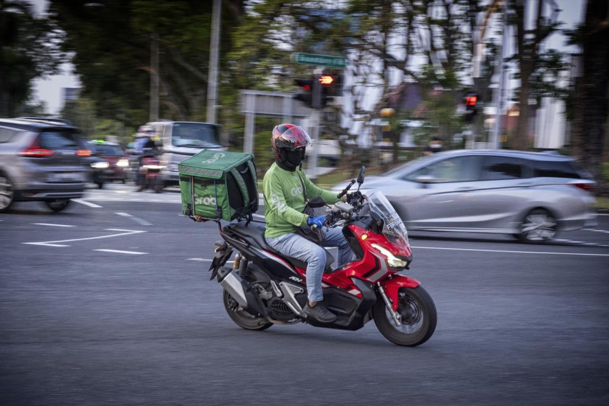 A GrabFood delivery rider on the road in Singapore, on Wednesday, May 18, 2022. Grab Holdings Ltd., is expected to report results on May 19. Photographer: Bryan van der Beek/Bloomberg