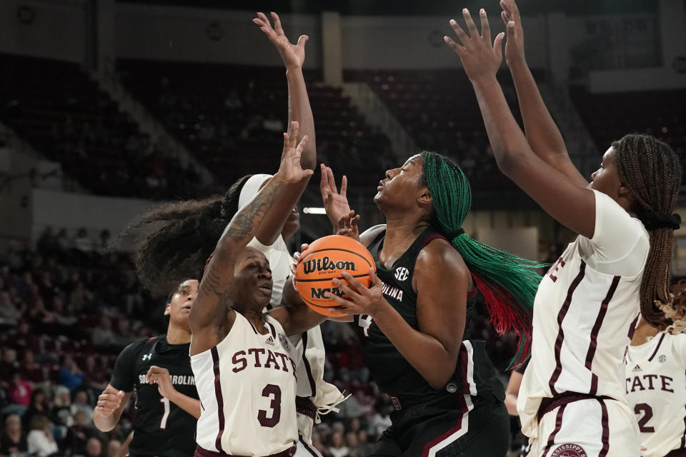 South Carolina forward Aliyah Boston (4) is defended by a number of Mississippi State players including guards Asianae Johnson (3) and Debreasha Powe, right, during the first half of an NCAA college basketball game in Starkville, Miss., Sunday, Jan. 8, 2023. (AP Photo/Rogelio V. Solis)