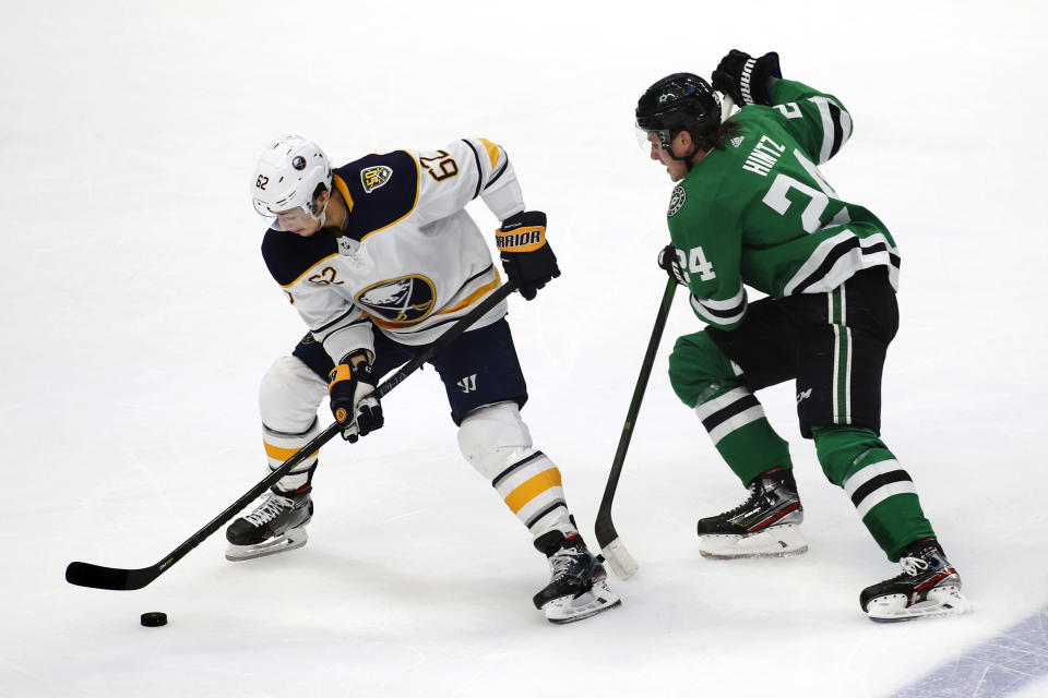 Buffalo Sabres defenseman Brandon Montour, left, controls the puck infront of Dallas Stars left wing Roope Hintz, right, during the first period of an NHL hockey game in Dallas, Thursday, Jan. 16, 2020. (AP Photo/Ray Carlin)