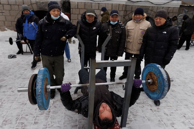 A man bench presses in Stalin Park, a popular place among the elderly, in Harbin