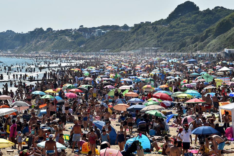 Beachgoers enjoy the sunshine as they sunbathe and swim on Bournemouth Beach in southern England on June 25. (Photo: GLYN KIRK via Getty Images)