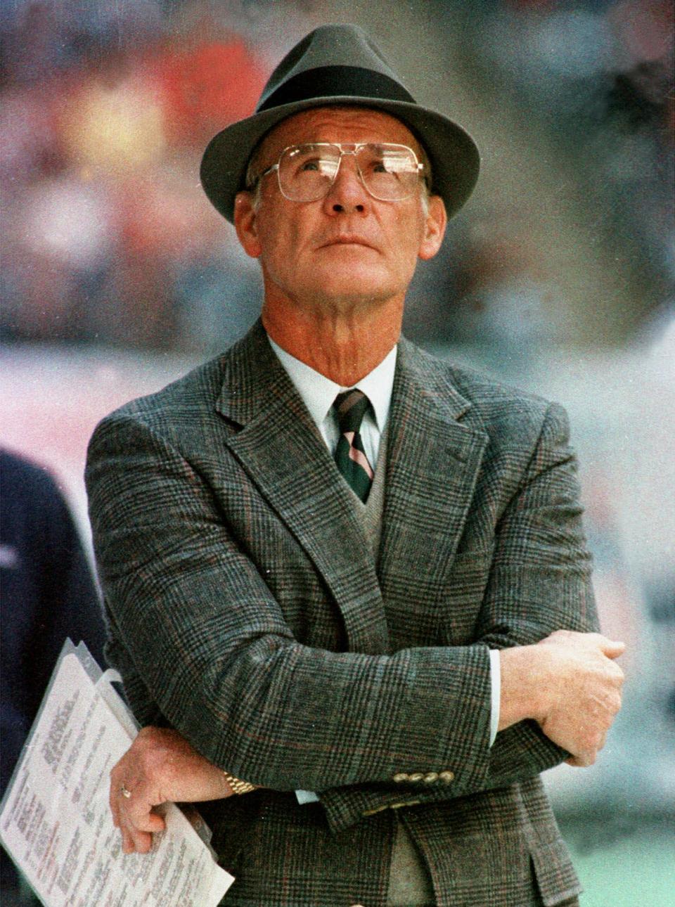 FILE - In this Dec. 18, 1988, file photo, Dallas Cowboys head coach Tom Landry watches from the sideline during an NFL football game against the Philadelphia Eagles in Irving, Texas. There are hats on the heads of more than half the coaches pictured in both NFL and college halls of fame, as well as sports coats, ties and even the occasional bow tie completing the look. Some looked so distinct _ Landry comes to mind _ that even decades later, you could identify them just by seeing their profiles. (AP Photo/Ron Heflin, File)