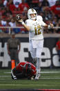 Florida International's Max Bortenschlager (12) throws away the ball while being tackled by Texas Tech's Brandon Bouyer-Randle (2) during the first half of an NCAA college football game on Saturday, Sept. 18, 2021, in Lubbock, Texas. (AP Photo/Brad Tollefson)